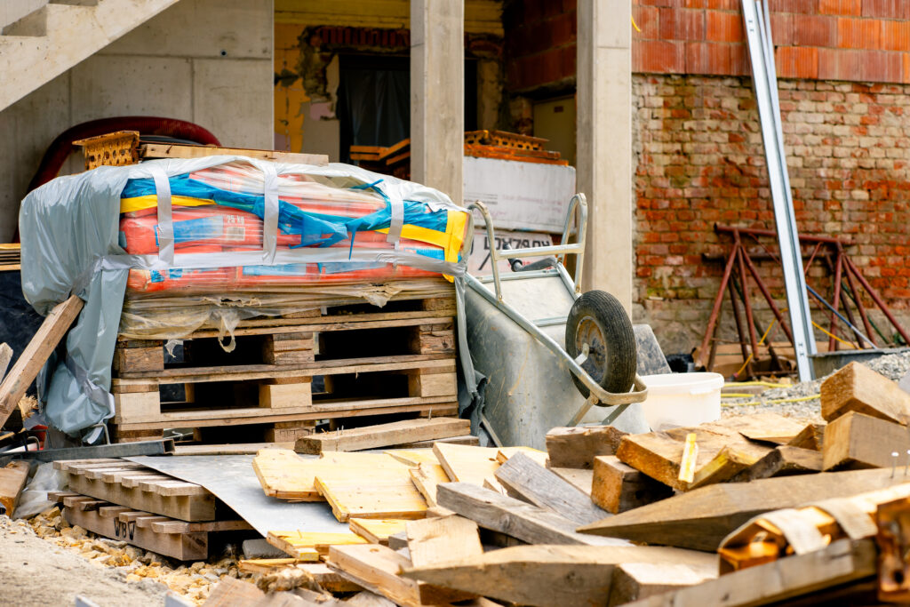 Various building materials and fixtures near a house under construction