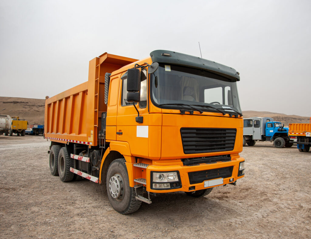 Closeup of an orange dumper truck in an construction area