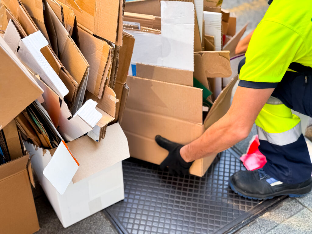 male adult collecting and organizing cardboard boxes for recycling
